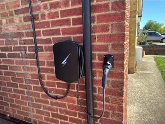 Wall-mounted EV charger installed on a red brick house