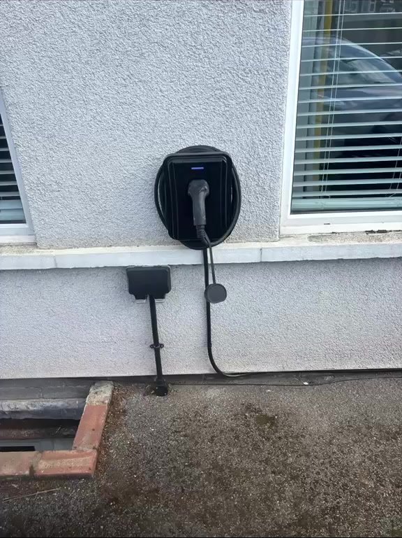 EV charger with a neat cable run on a rendered house wall