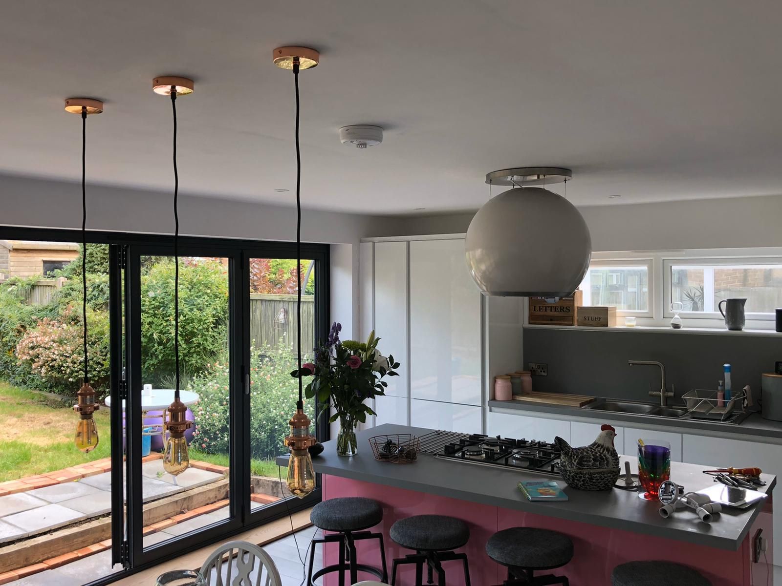 Open-plan kitchen extension with copper pendant lights and downlights, wired by Harris Electrical