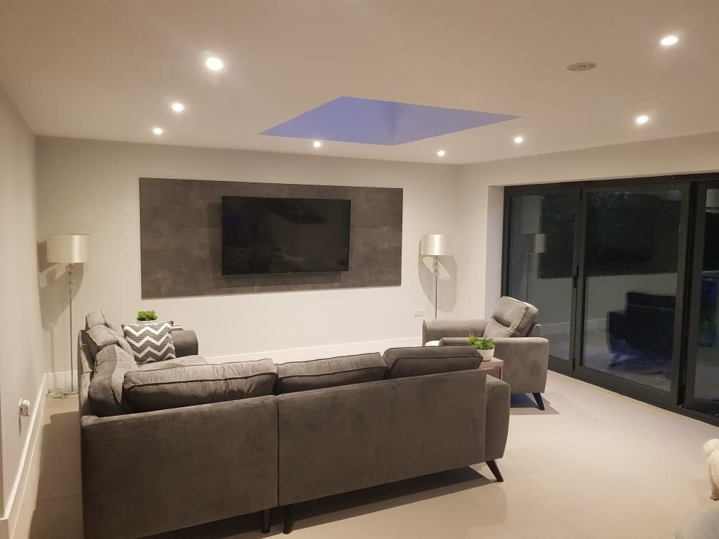 Finished extension living room with downlights and a TV wall